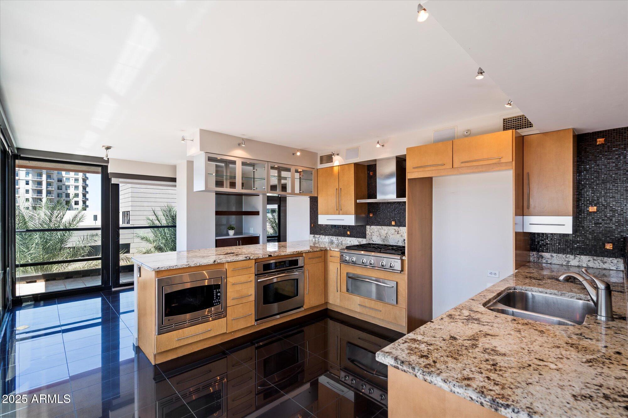 4808 North 24th Street, Unit 627 Phoenix, AZ 85016 - Photo 18 of 57 a kitchen with stainless steel appliances granite countertop a stove top oven a sink and a refrigerator