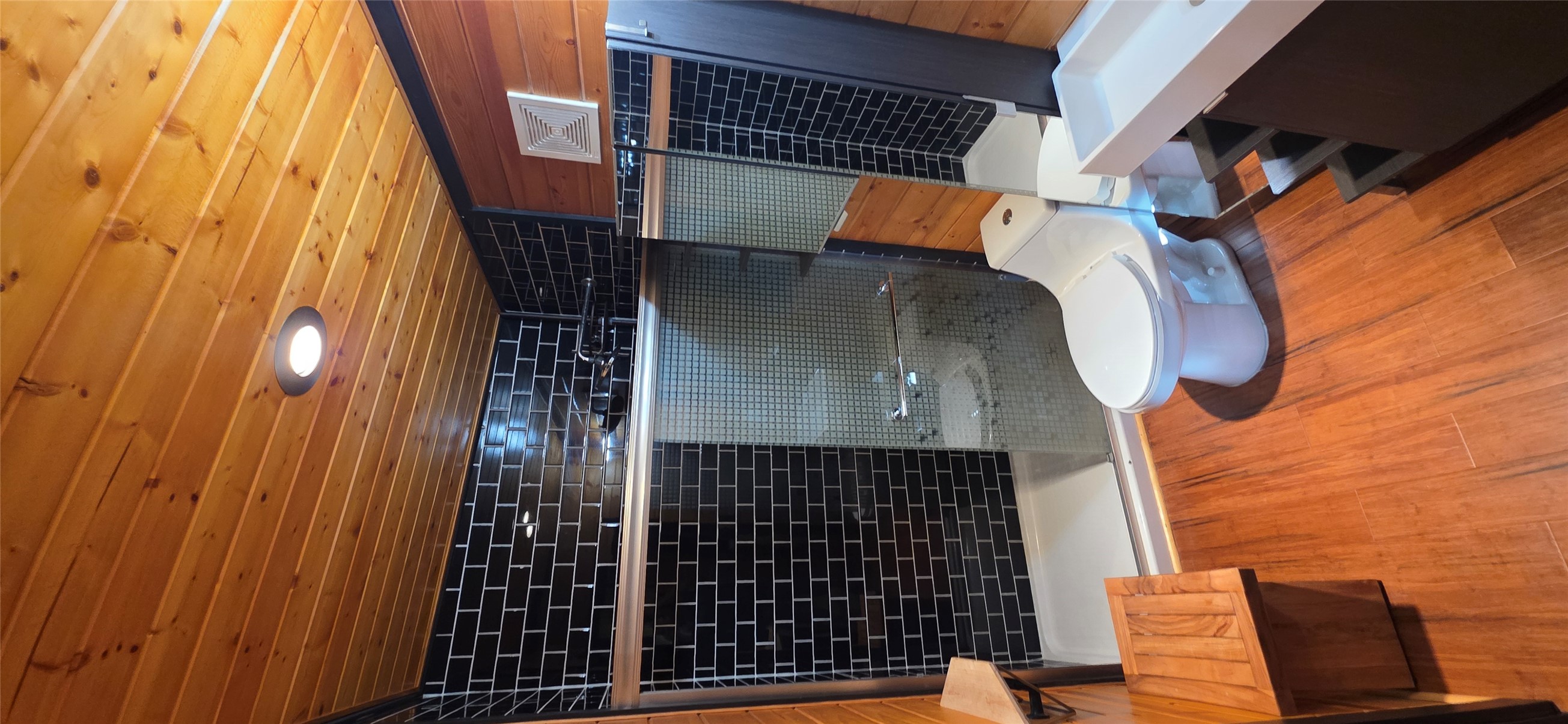 916 South Main Street Lockhart, TX 78644 - Photo 3 of 18 A well-appointed bathroom features striking black subway tile in the shower and warm wood flooring.