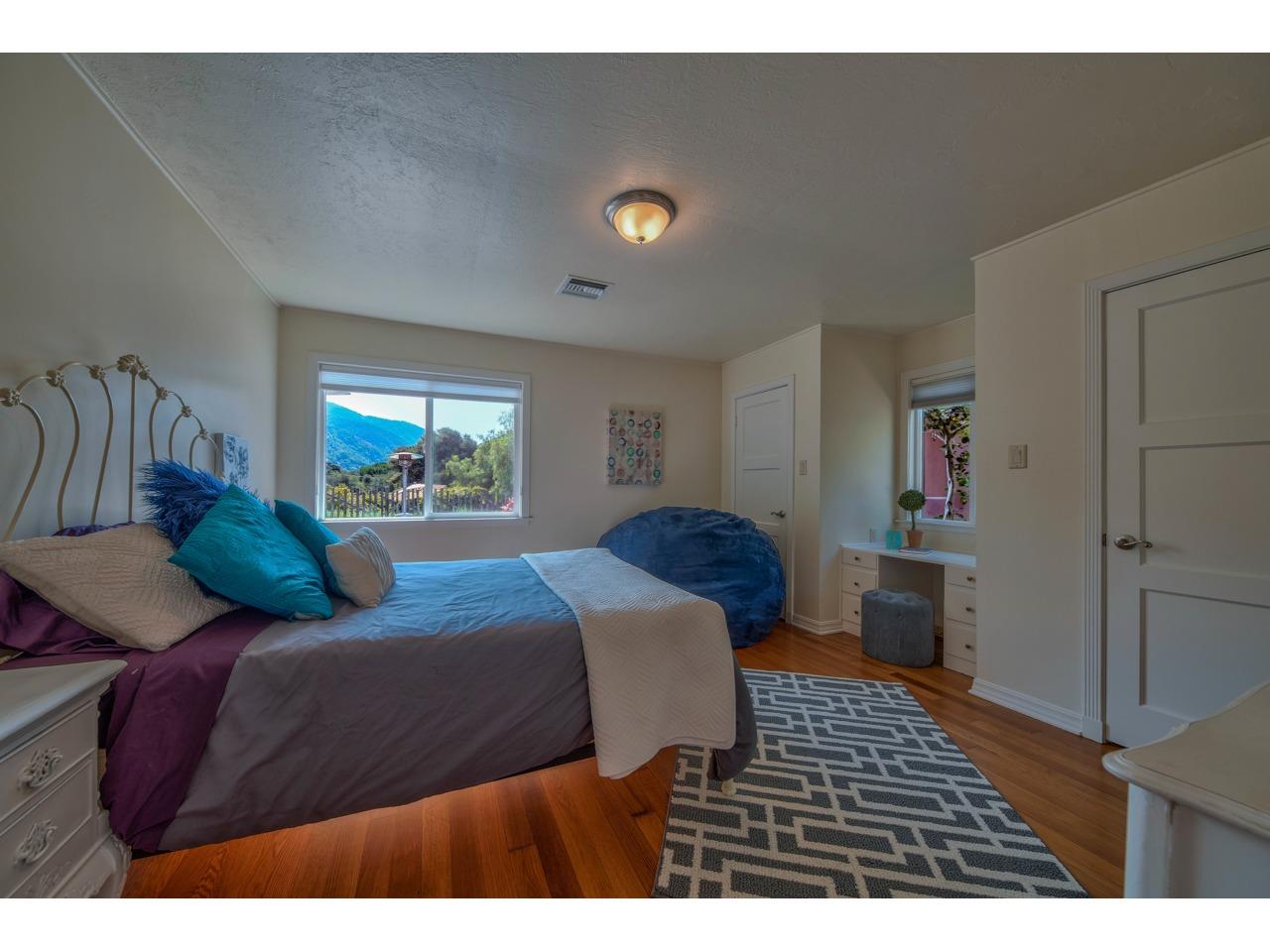 308 West Carmel Valley Road Carmel Valley, CA 93924 - Photo 28 of 49 a bedroom with a bed and dresser with mirror