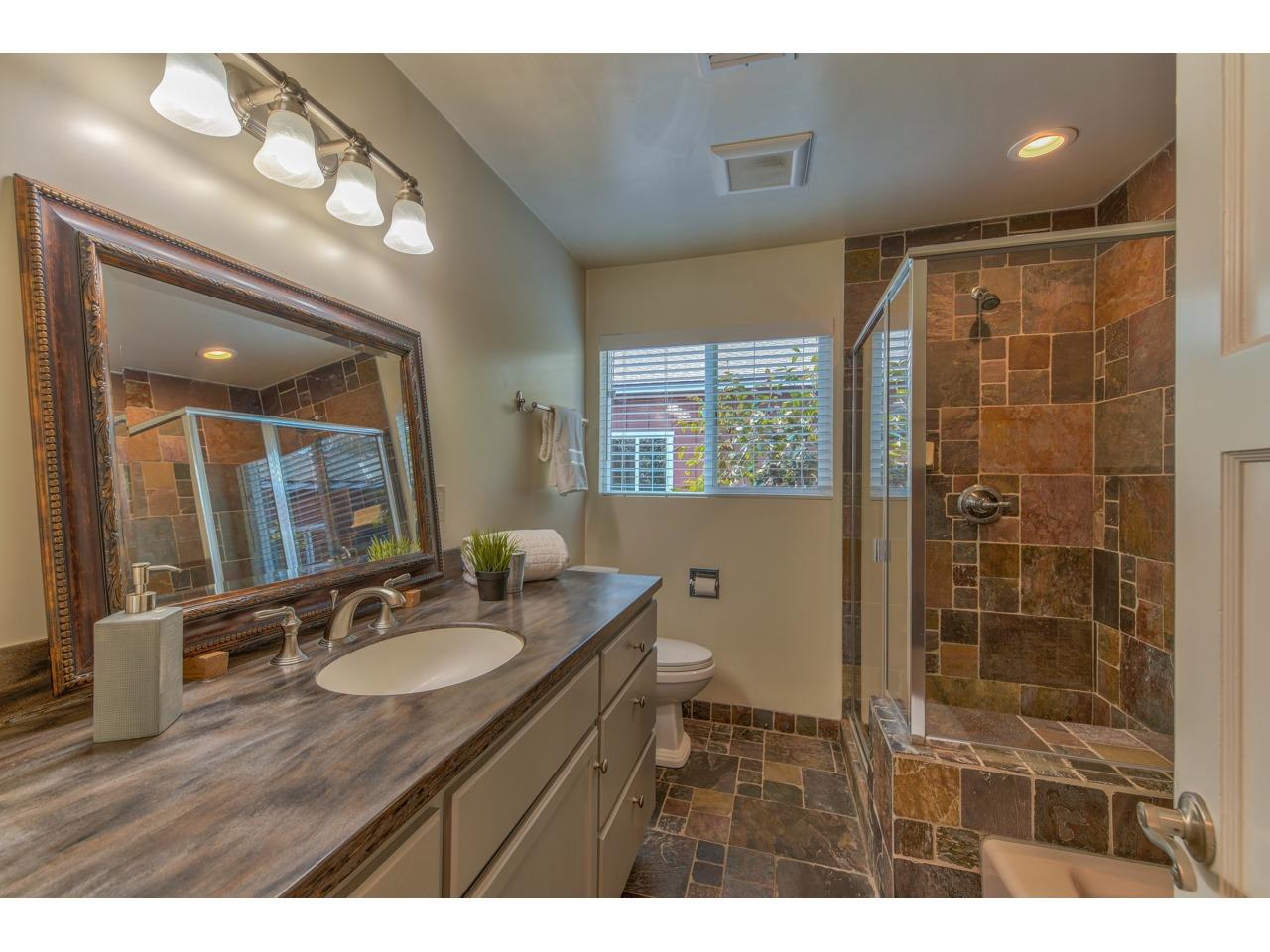 308 West Carmel Valley Road Carmel Valley, CA 93924 - Photo 31 of 49 a bathroom with a granite countertop sink a mirror and a shower