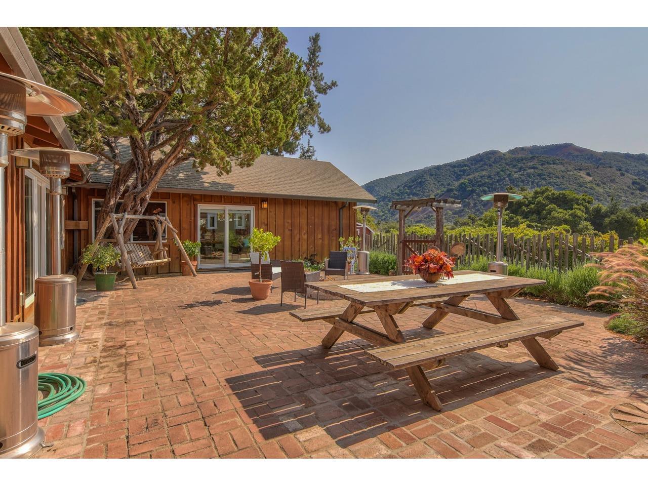 308 West Carmel Valley Road Carmel Valley, CA 93924 - Photo 33 of 49 a view of a patio with a table and chairs under an umbrella