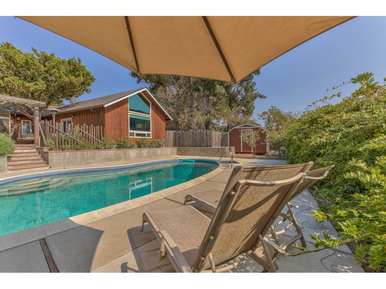 308 West Carmel Valley Road Carmel Valley, CA 93924 - Photo 35 of 49 a view of a backyard with table and chairs under an umbrella