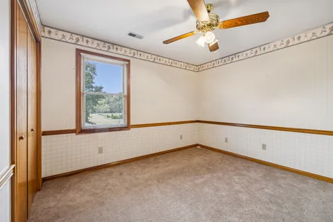 a view of a house with a big yard and large trees