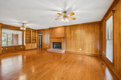 a view of an empty room with a fireplace and a window