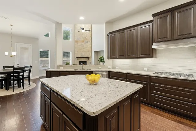 a kitchen with a sink a stove and wooden cabinets