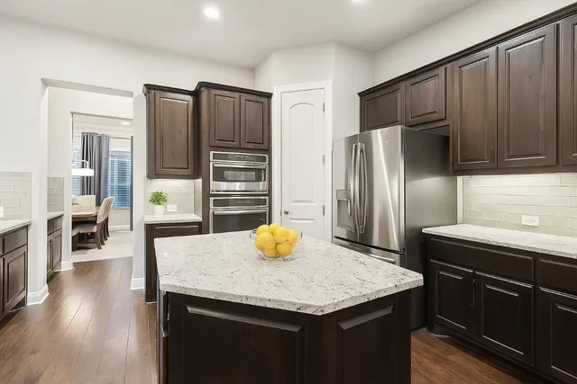 a kitchen with stainless steel appliances wooden floor and wooden cabinets