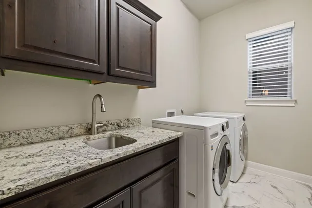 a utility room with sink dryer and washer