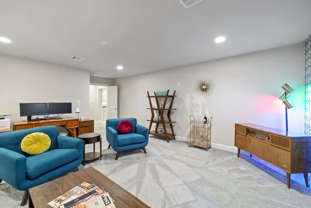 a living room with furniture a flat screen tv and gym equipment