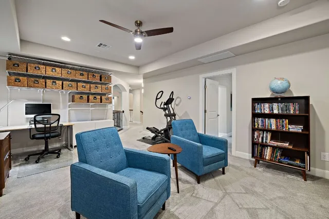 a living room with furniture and a book shelf