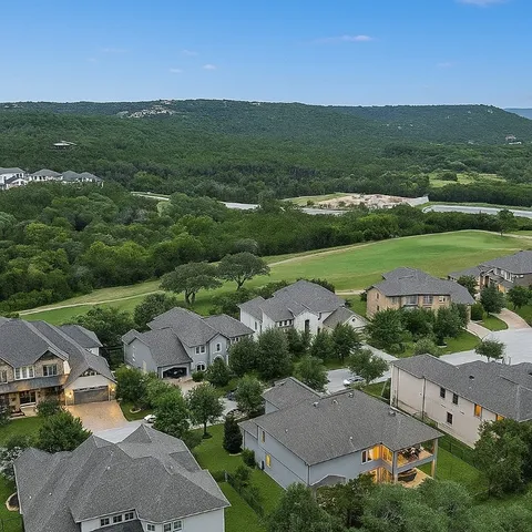 an aerial view of residential houses with outdoor space and street view