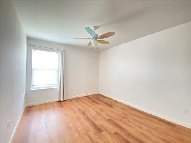 an empty room with a window and a fan