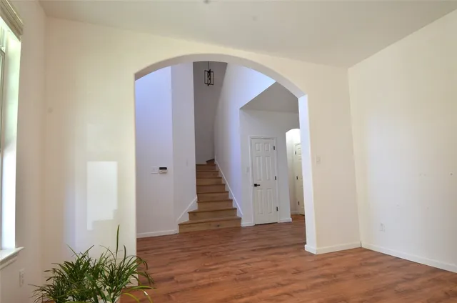an empty room with wooden floor and entryway