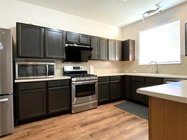 a kitchen with stainless steel appliances kitchen island granite countertop a stove microwave and refrigerator