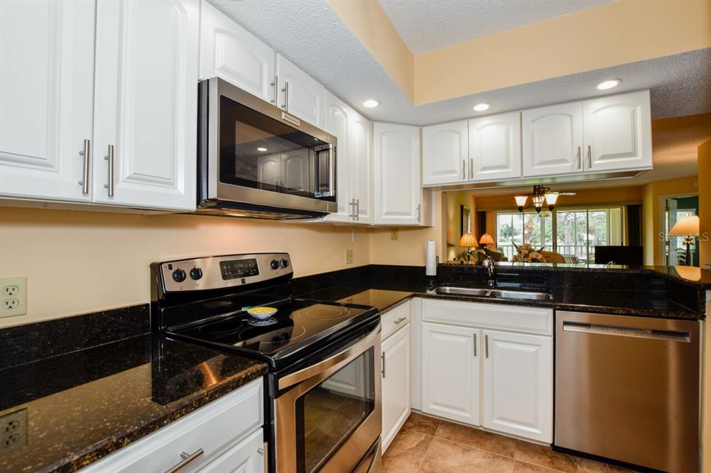 433 Cerromar Lane, Unit 438 Venice, FL 34293 - Photo 12 of 44 a kitchen with a sink stove and microwave