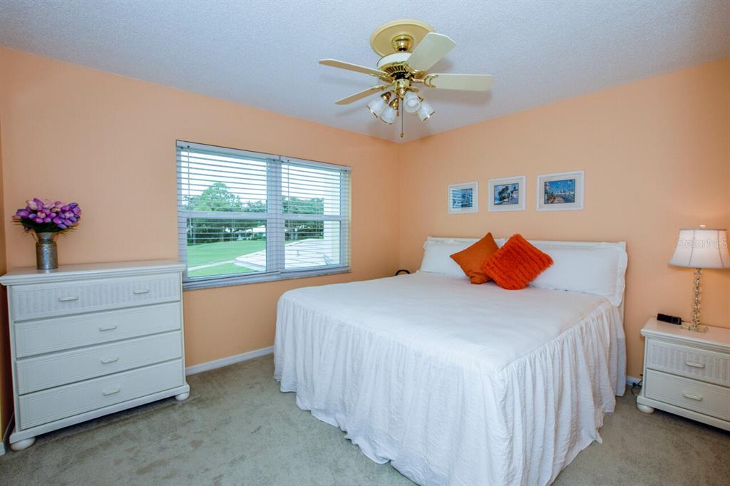 433 Cerromar Lane, Unit 438 Venice, FL 34293 - Photo 20 of 44 a bedroom with a bed and a chandelier