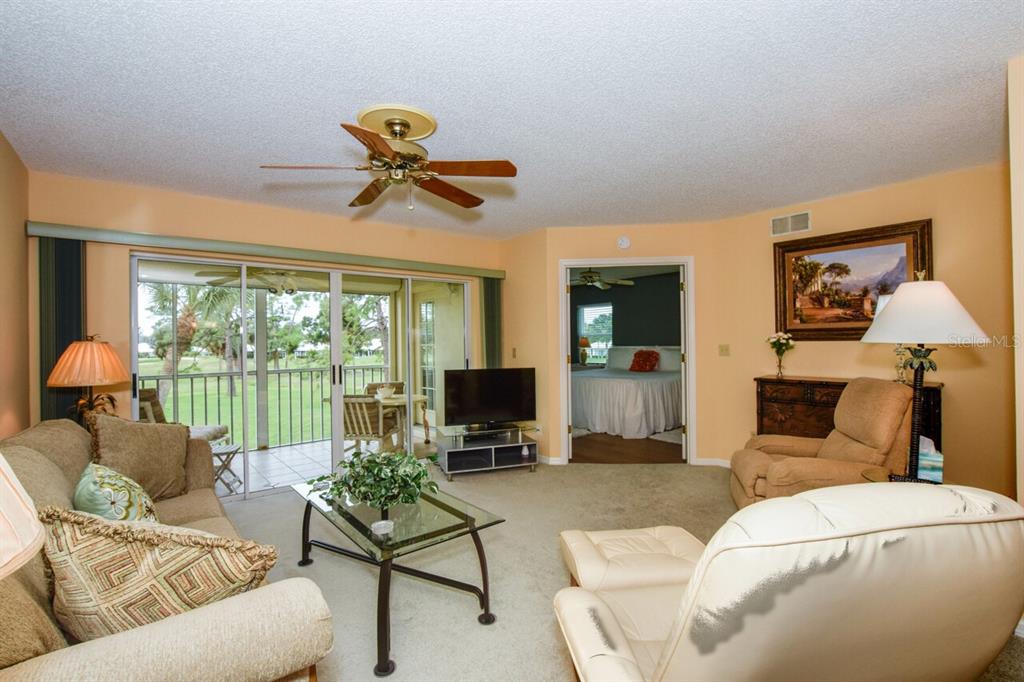 433 Cerromar Lane, Unit 438 Venice, FL 34293 - Photo 7 of 44 a living room with furniture and a flat screen tv