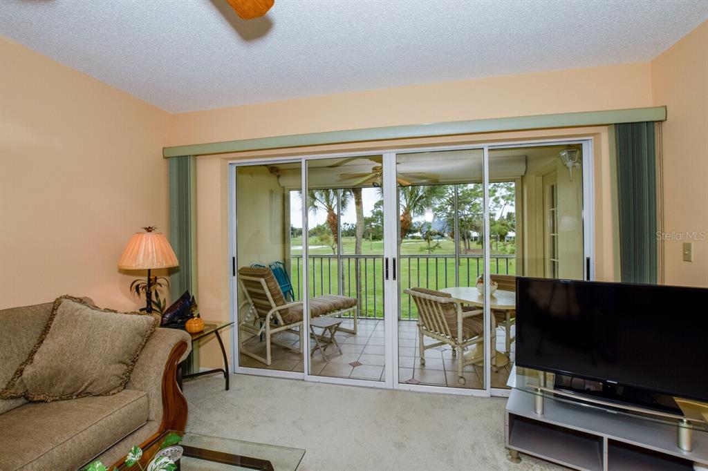 433 Cerromar Lane, Unit 438 Venice, FL 34293 - Photo 10 of 44 a living room with furniture and a flat screen tv