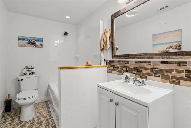 a bathroom with a sink toilet and a mirror