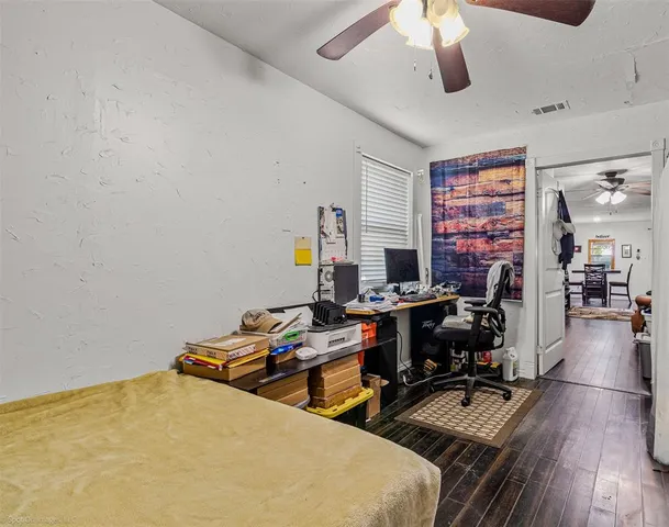 a view of a workspace with furniture and a ceiling fan