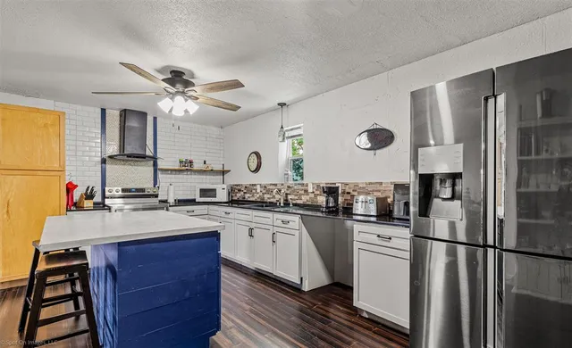 a kitchen with granite countertop a sink stainless steel appliances and cabinets