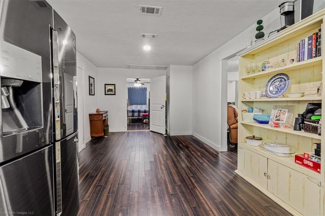 a kitchen with stainless steel appliances a refrigerator and wooden floor