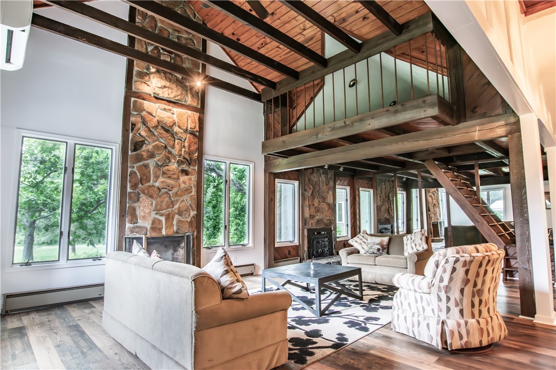 200 Chenault Road Townville, SC 29689 - Photo 8 of 47 An inviting great room with soaring ceilings, exposed beams, and a grand stone fireplace.