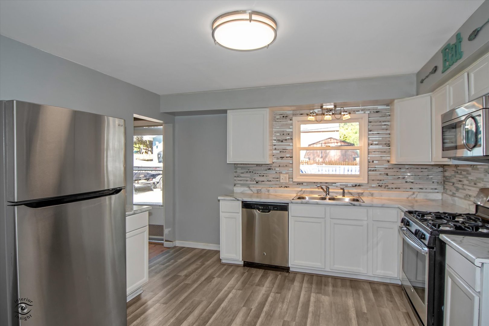 128 North Pinecrest Road Bolingbrook, IL 60440 - Photo 6 of 25 a kitchen with a sink stainless steel appliances a window and a counter top space