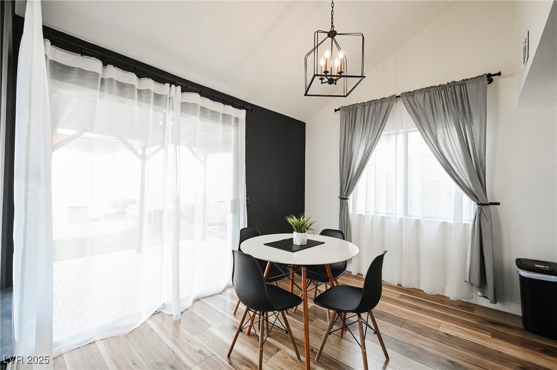 1640 Crystal Shadows Circle Las Vegas, NV 89119 - Photo 7 of 44 Dining area with wood finished floors, vaulted ceiling, and a chandelier