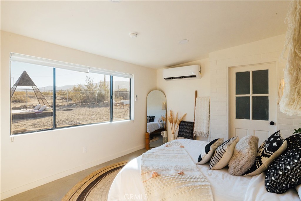 75243 Sullivan Road Twentynine Palms, CA 92277 - Photo 35 of 62 a bedroom with a bed and a large window