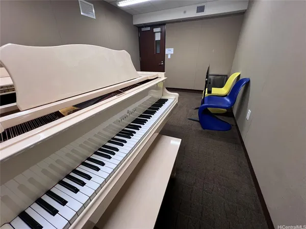 a living room with furniture and a piano