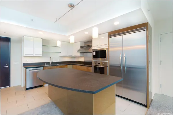 a kitchen with stainless steel appliances granite countertop a sink a stove a refrigerator a washer dryer and white cabinets