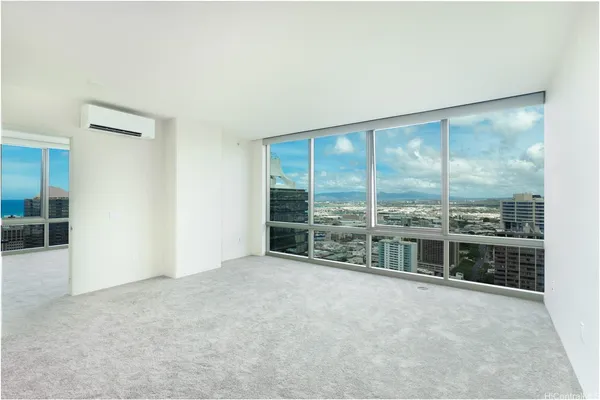 an empty room with floor to ceiling window and an outdoor view