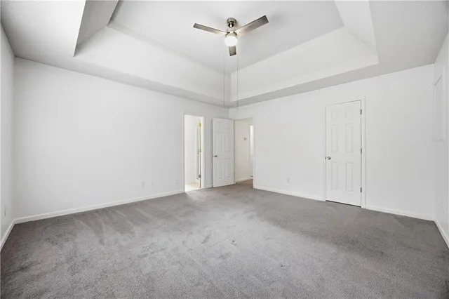 an empty room with a ceiling fan and a window