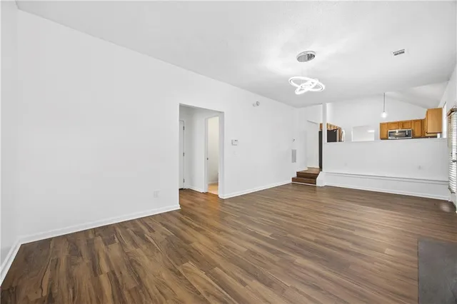 a view of empty room with wooden floor