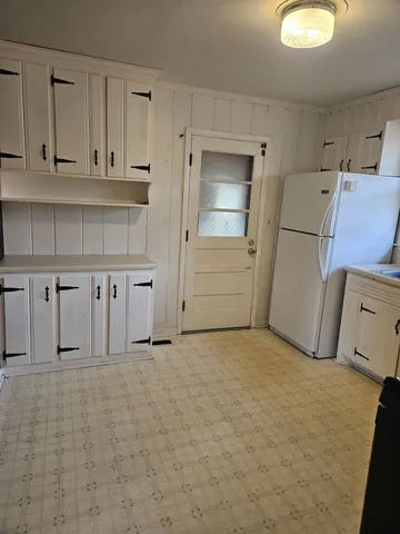 a kitchen with white cabinets and black appliances
