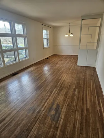 a view of a kitchen with refrigerator and white cabinets
