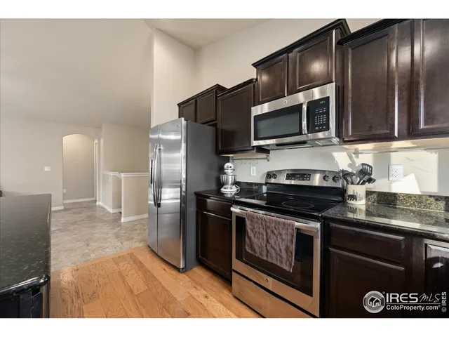 a bedroom with a bed next to a window with a ceiling fan