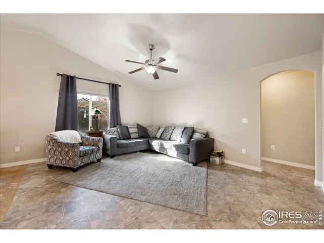 a living room with furniture and a view of kitchen