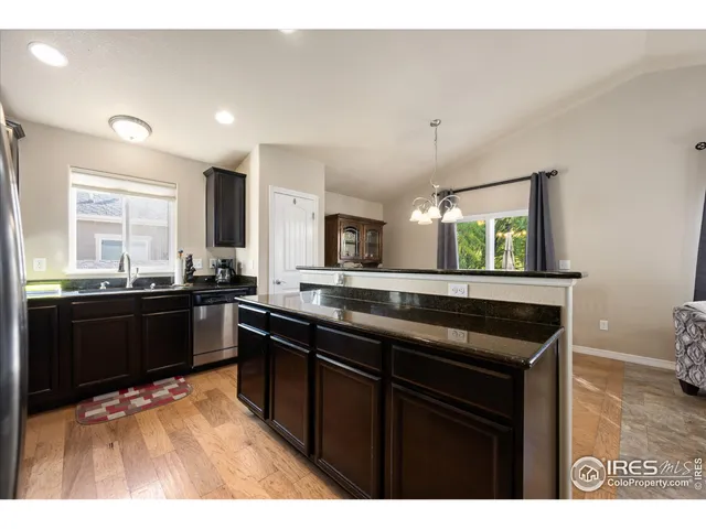 a kitchen with stainless steel appliances kitchen island granite countertop a refrigerator stove and sink