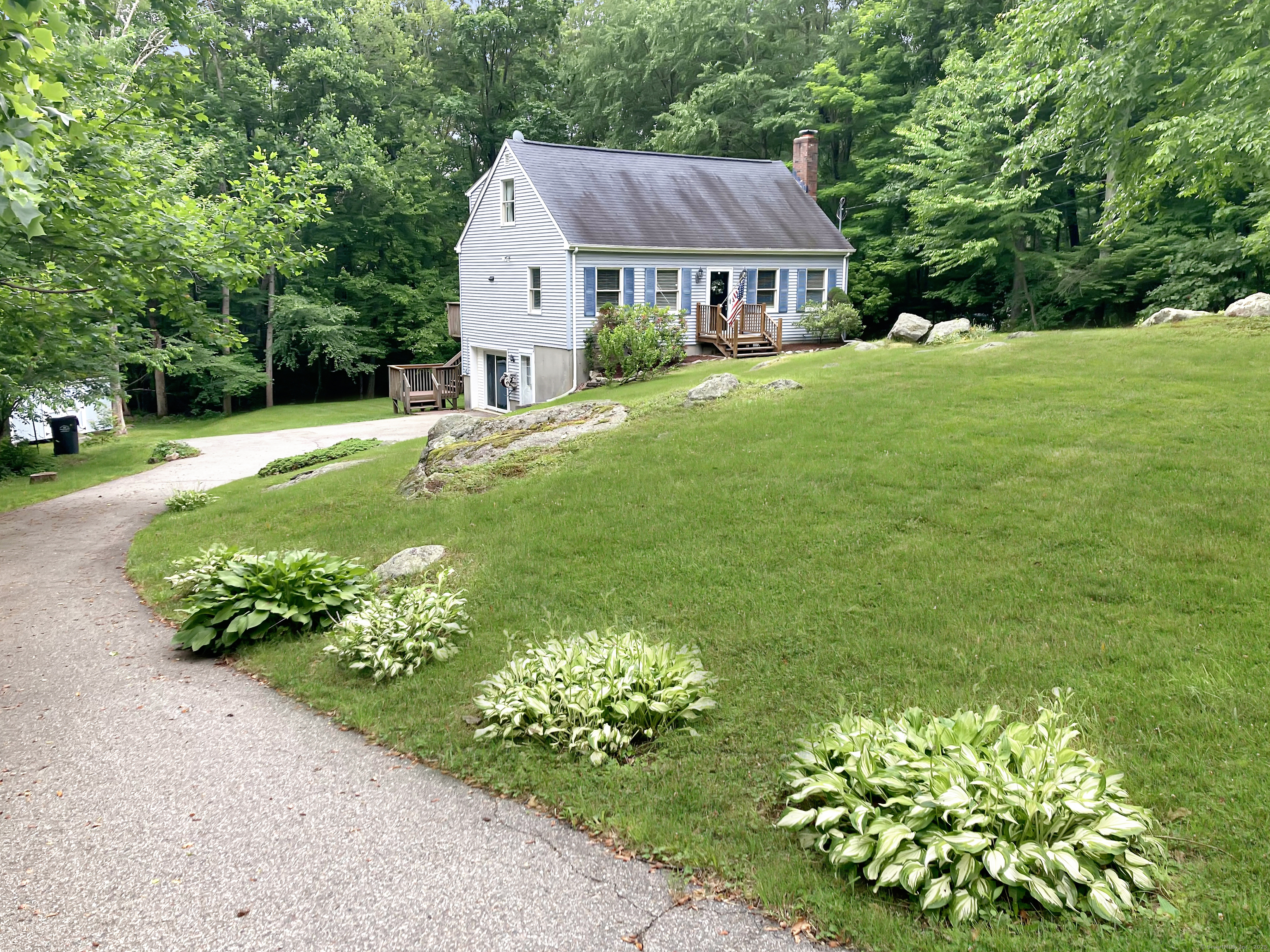 a view of a house with a big yard and potted plants