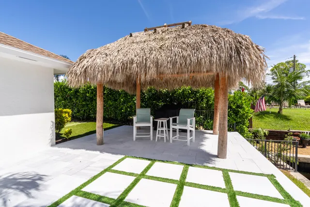 a view of a patio with a table and chairs under an umbrella