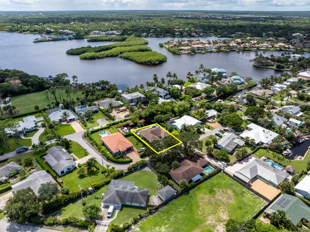 an aerial view of residential houses with outdoor space and lake view