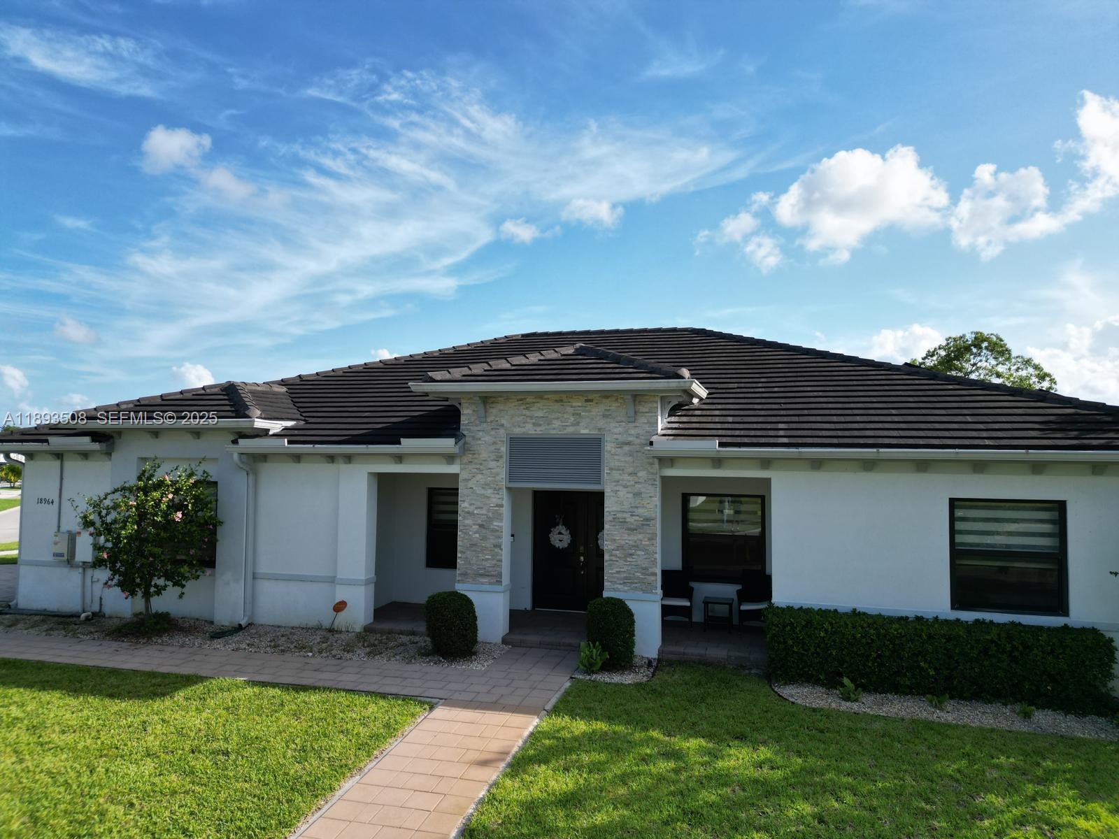 18964 Southwest 135th Avenue Miami, FL 33177 - Photo 1 of 39 a front view of a house with a yard and garage