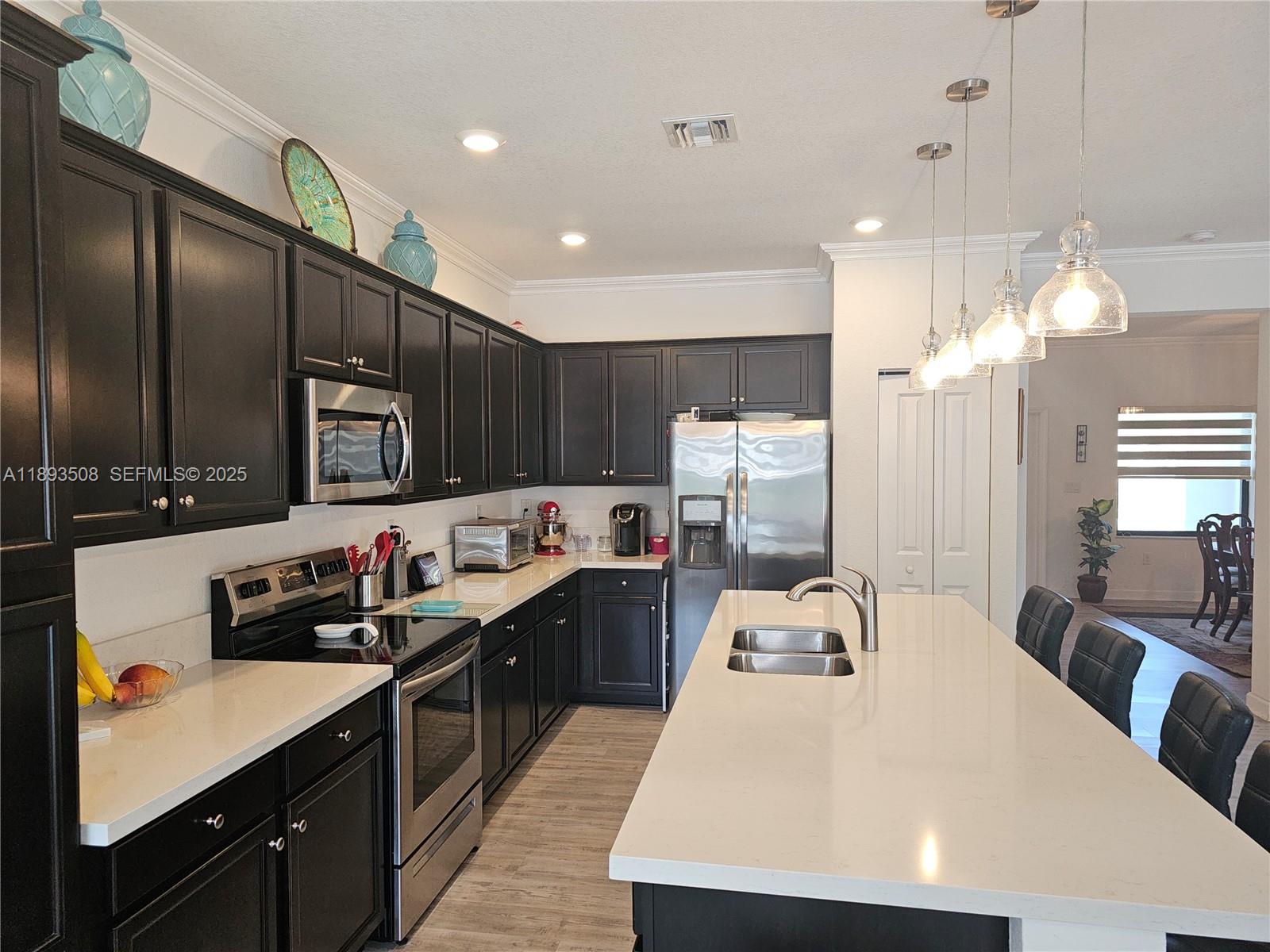 18964 Southwest 135th Avenue Miami, FL 33177 - Photo 16 of 39 a large kitchen with kitchen island a sink stainless steel appliances and cabinets