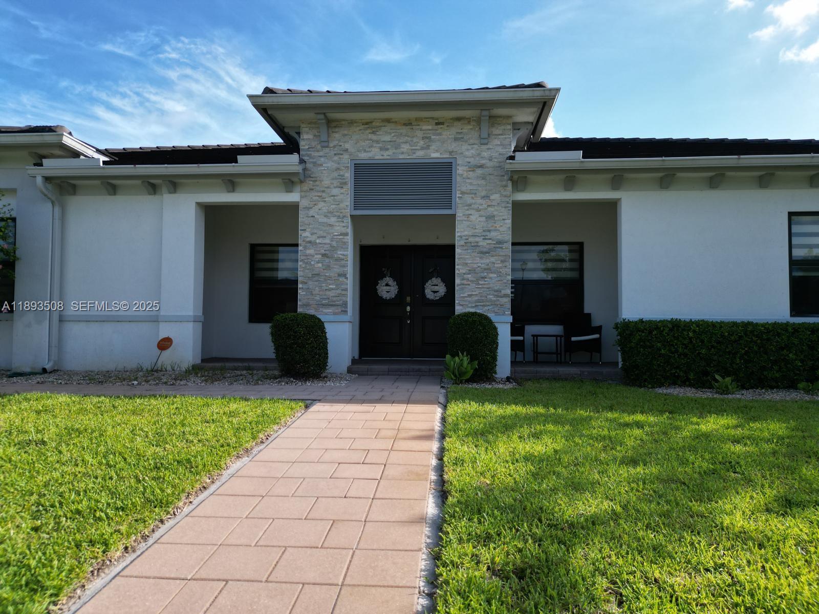 18964 Southwest 135th Avenue Miami, FL 33177 - Photo 2 of 39 a house view with a garden space