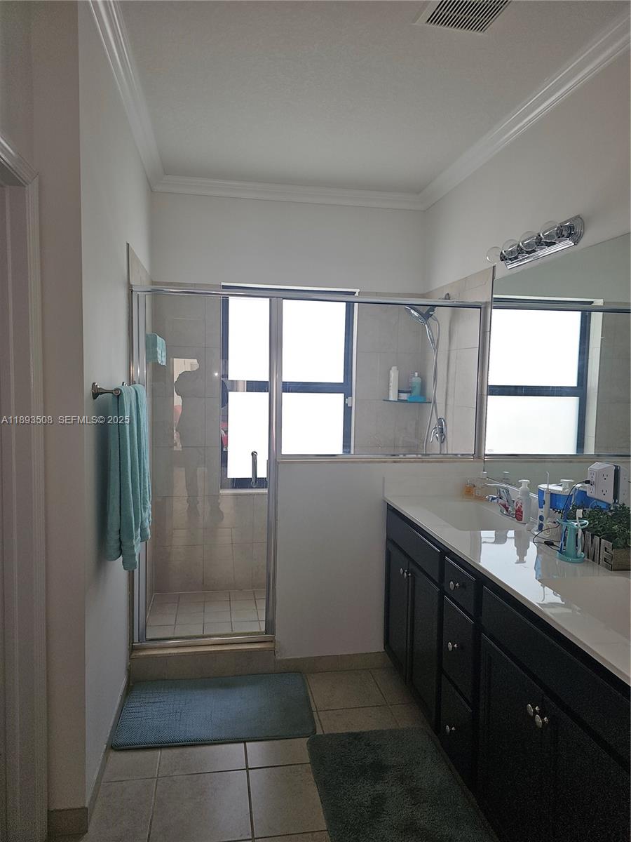 18964 Southwest 135th Avenue Miami, FL 33177 - Photo 23 of 39 a bathroom with a granite countertop sink a mirror and a shower