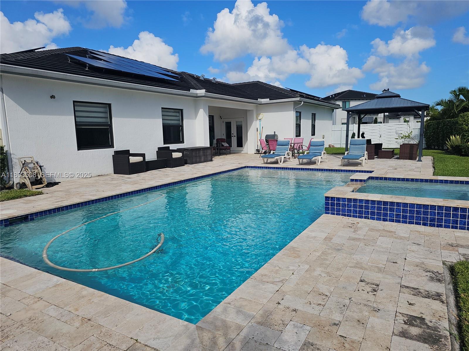 18964 Southwest 135th Avenue Miami, FL 33177 - Photo 27 of 39 a front view of a house with swimming pool having outdoor seating