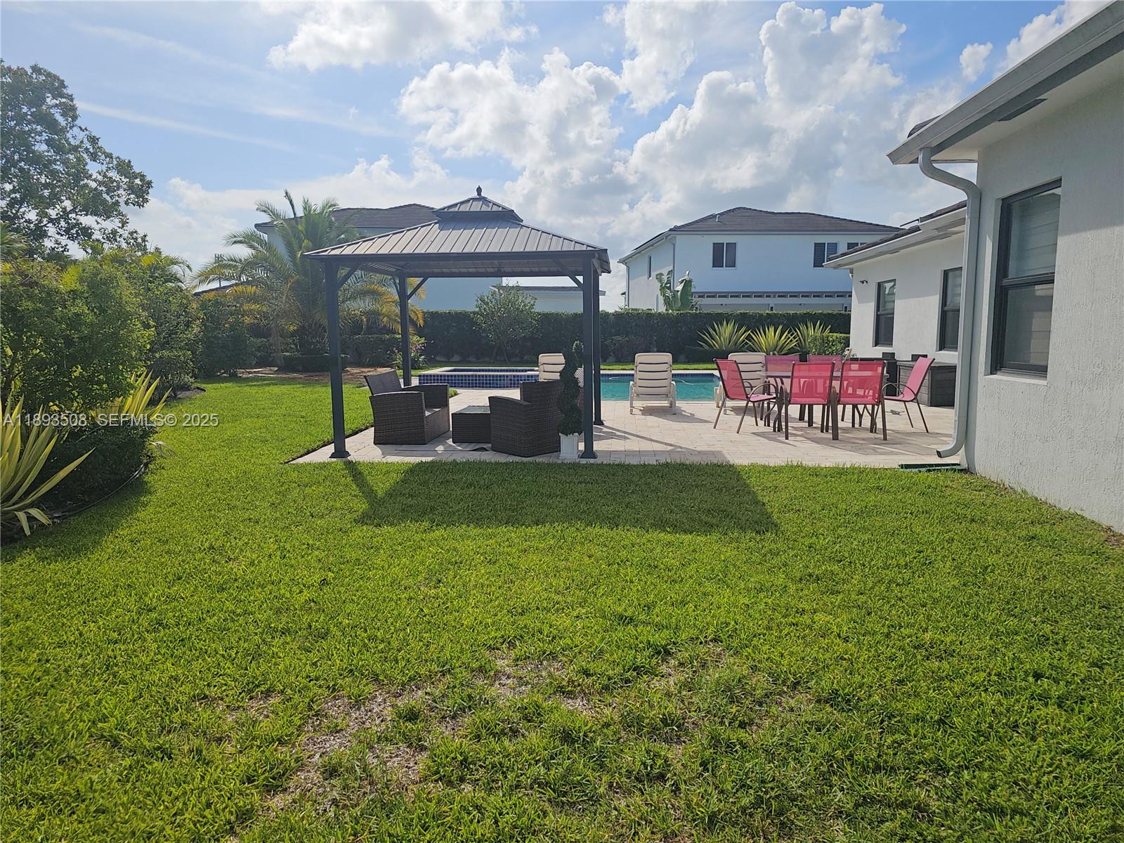 18964 Southwest 135th Avenue Miami, FL 33177 - Photo 29 of 39 a view of a chairs and table in the patio next to a yard