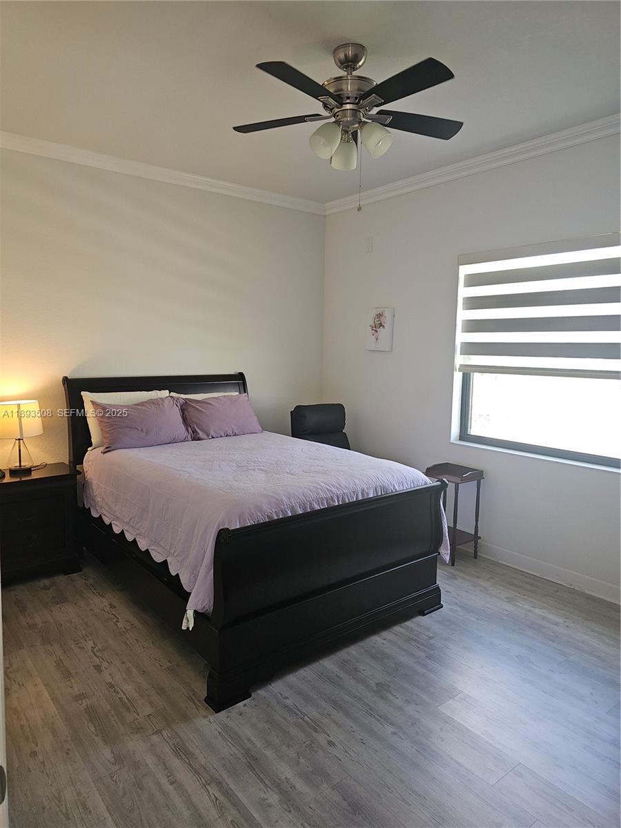 18964 Southwest 135th Avenue Miami, FL 33177 - Photo 8 of 39 a bedroom with a bed a chandelier and a window