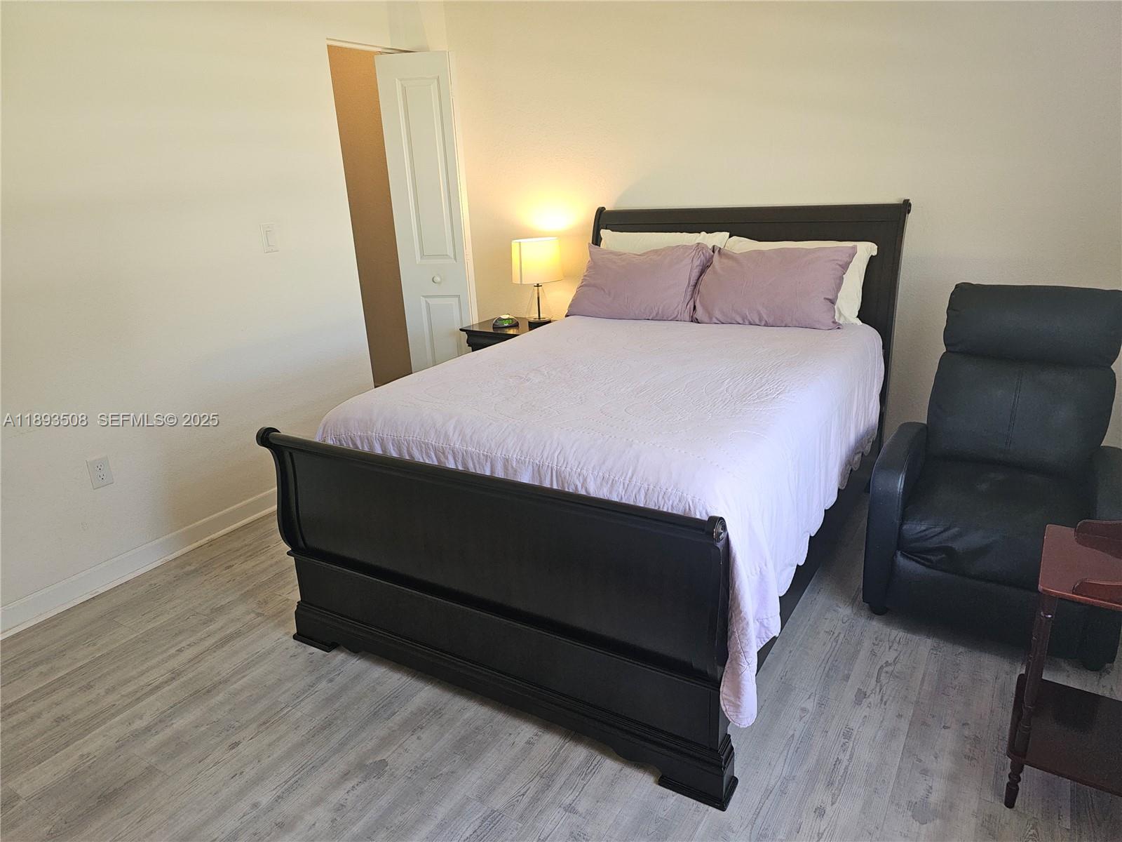 18964 Southwest 135th Avenue Miami, FL 33177 - Photo 9 of 39 a bed sitting in a bedroom next to a window with wooden floor